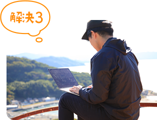 自然の中でノートパソコンを開いている男性